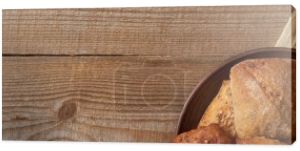 Widok z góry świeżego chleba chleb i bułki w misce na tkaninie na drewnianym stole, panoramiczny strzał