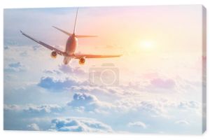 Samolot leci nad piękne puszyste chmury na malowniczy zachód słońca. Koncepcja podróże i wakacje.