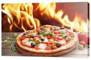 Pyszne gorące pizzy na drewnianym stole tle płomień ognia