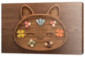 Widok z góry kotów suchej karmy dla zwierząt domowych i witamin w ładny koci kształt płyty na drewnianym stole
