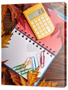 Notatnik, kalkulator i jesiennych liści