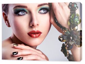 Piękna twarz kobiety z moda zielony makijaż i biżuteria na h