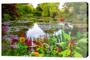 Ogród i staw Moneta w Giverny we Francji. Piękny ogród i staw z kępami kolorowych kwiatów, różnorodnymi drzewami i krzewami latem w Giverny.