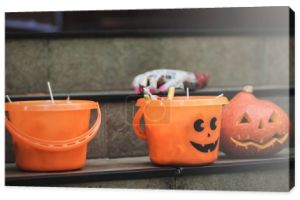 wiadra halloween ze słodyczami w pobliżu rzeźbionej dyni i rozmyta ręka zabawki na schodach
