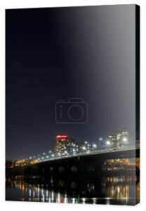 ciemny pejzaż z oświetlone budynki, światła, most i rzeka
