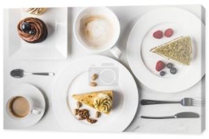 Widok z góry układu kawałków różnych ciast na talerze, filiżanki, Kawa i babeczki na białym tle