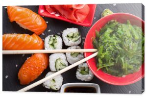 sushi i bułki z czerwienią i sosem na łupkowym stole