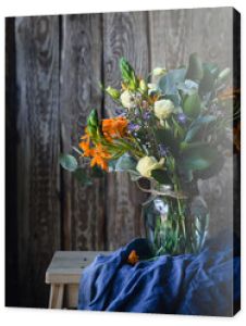 Wiosenne kwiaty na drewnianym krześle z niebieskim materiałem na drewnianym tle