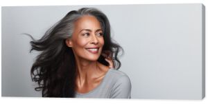 Beautiful black woman with smooth healthy face skin. Gorgeous aging mature woman with long gray hair and happy smiling. Beauty and cosmetics skincare advertising concept.