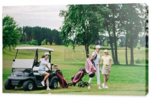 Grupa kobiet graczy w czapki z sprzętu golfowego na polu golfowym w letni dzień