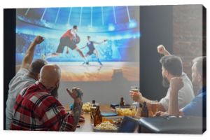 Men, friends sitting at table with beer and snacks, watching online basketball game translation on TV and cheering up favorite team. Concept of sport, championship, game, sport fans, leisure