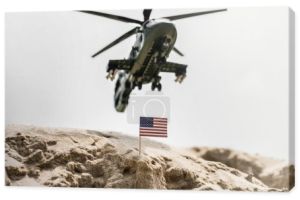 Selektywna koncentracja małej amerykańskiej flagi na wydmach z helikopterem wojskowym powyżej