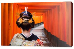 Kobieta w tradycyjnym kimonie spacerująca przy bramach torii, Japonia