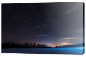 Mroczne niebo pełne gwiazd błyszczących w Karpatach zimą w nocy